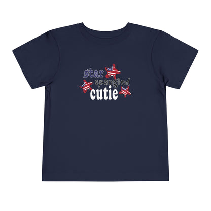 Navy toddler t-shrit laying flat with typography and patriotic stars, t-shirt says "star spangled cutie"