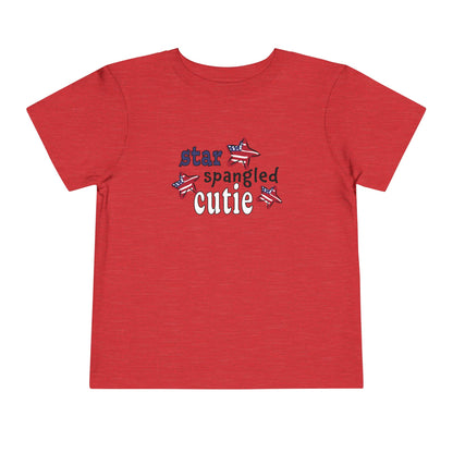 Red toddler t-shrit laying flat with typography and patriotic stars, t-shirt says "star spangled cutie"