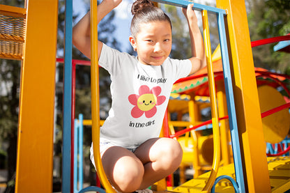 Kids’ dirt-loving t-shirt in playful outdoor setting- I love to play in the dirt with a pink flower