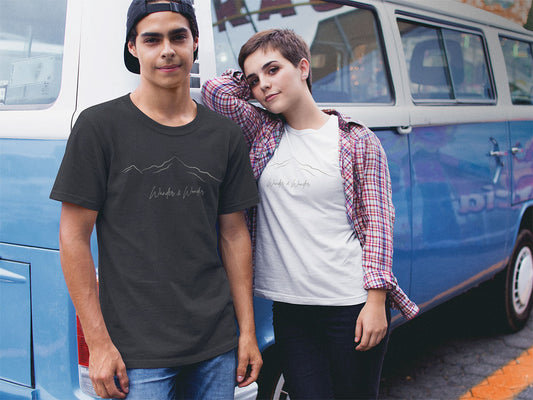 Couple wearing unisex mountain graphic t-shirt in front of retro camper