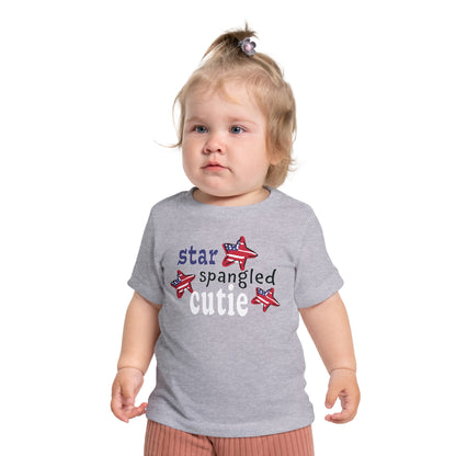 Baby wearing a athletic heather t-shrit with typography and patriotic stars, t-shirt says "star spangled cutie"