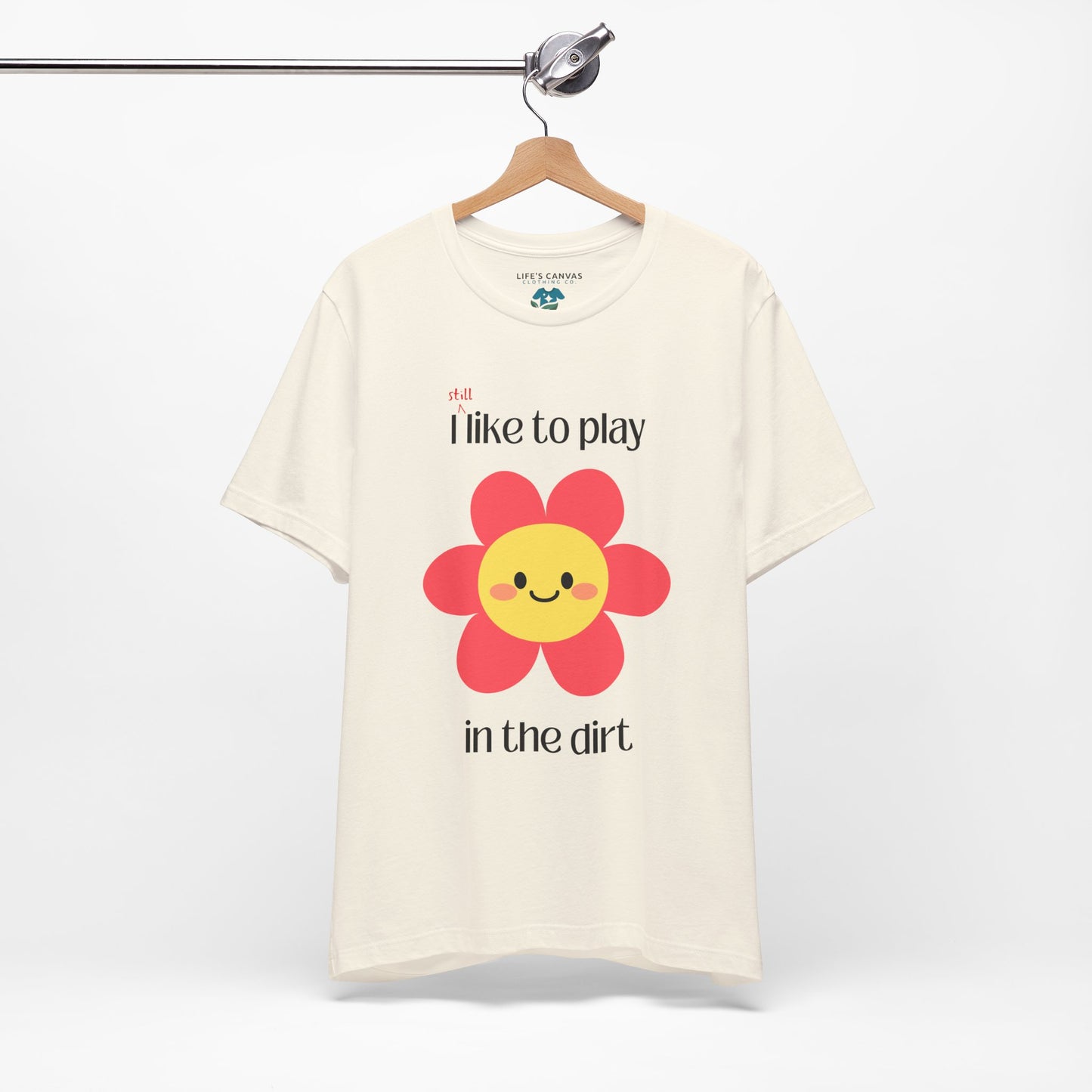 Natural t-shirt on a hanger with a  pink flower- I still like to play in the dirt
