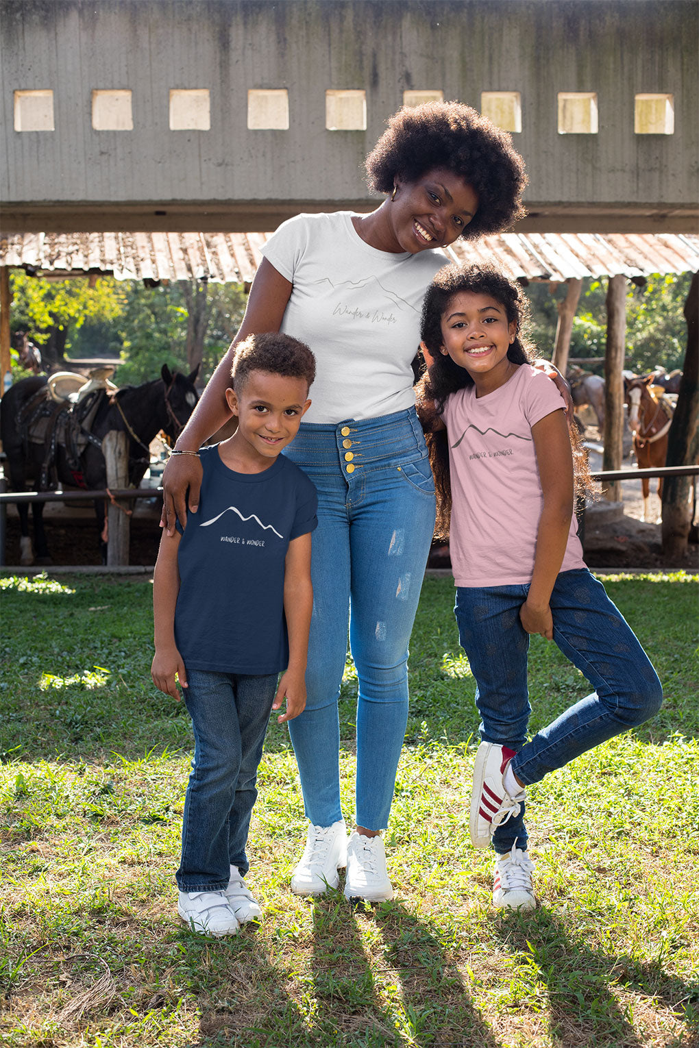 Sibling Youths wearing "wander and Wonder" minimalist mountain design t-shirt with parent