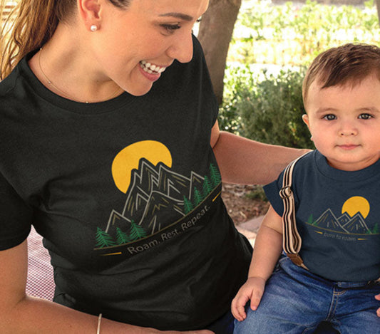 Mom and baby wearing matching minimal tees Unisex black tee with mountain and text "roam rest repeat"