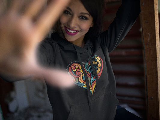 Woman wearing unisex fleece hoodie featuring colorful heart design and inspiring art quote.