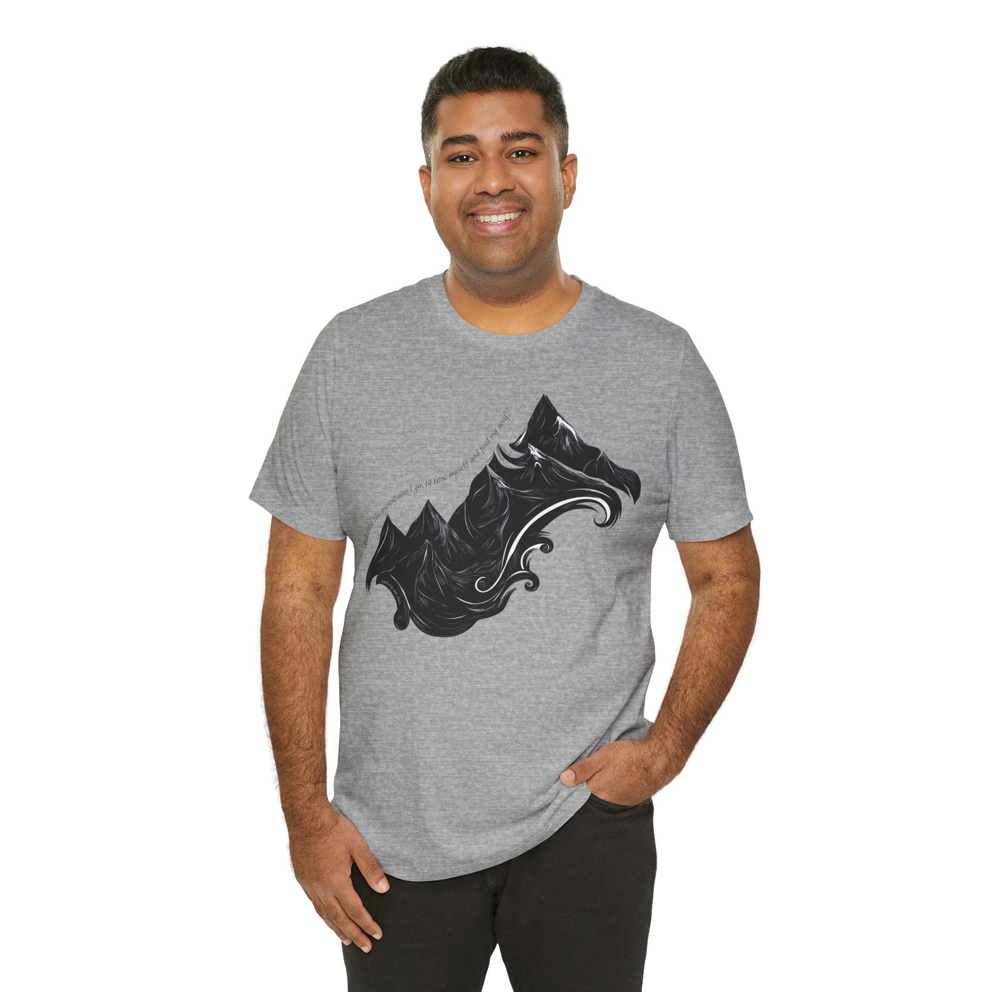 Unisex t-shirt with sketched mountain design and John Muir quote “Into the Mountains I go...”- Athletic Heather on a model