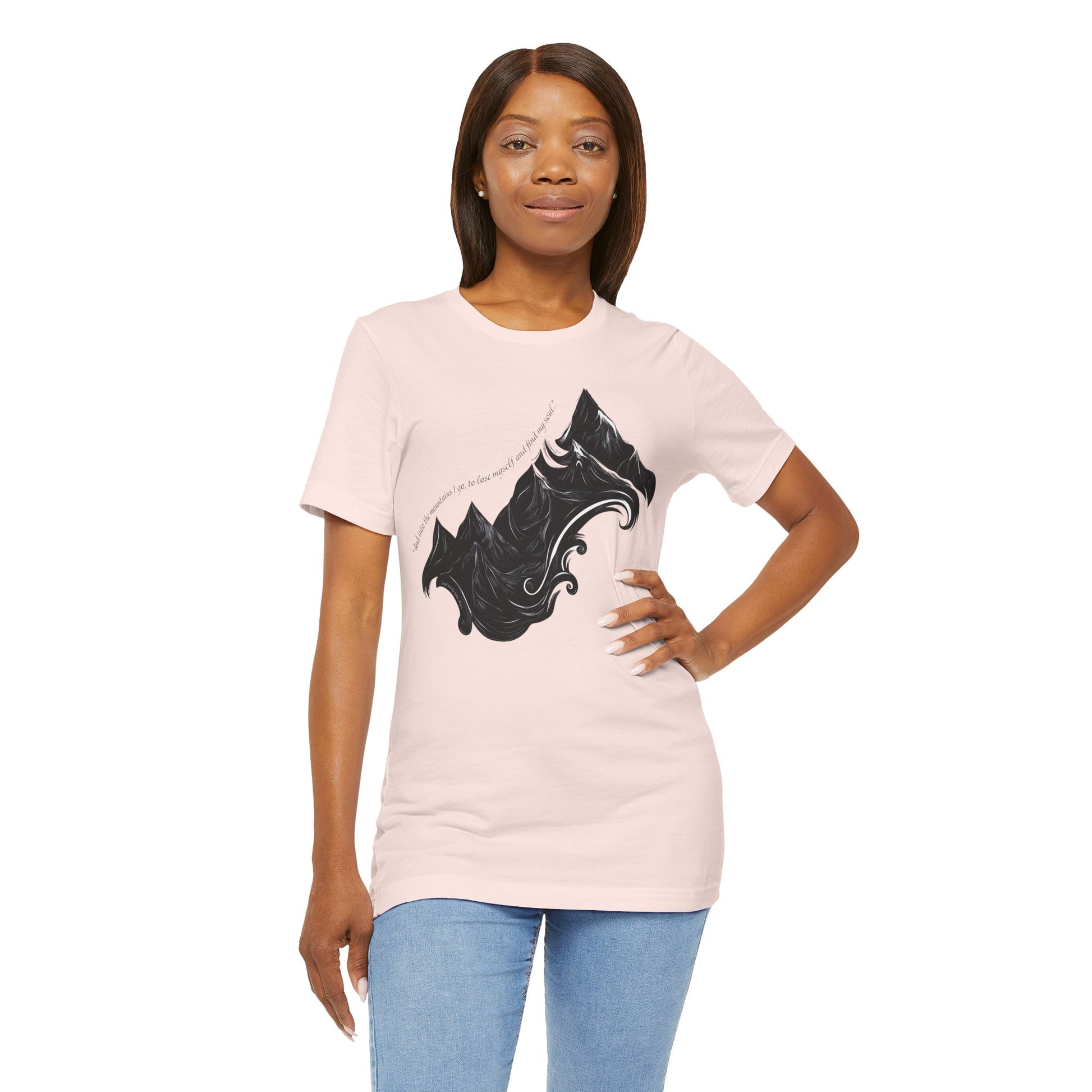 Unisex t-shirt with sketched mountain design and John Muir quote “Into the Mountains I go...”- Soft Pink on a model