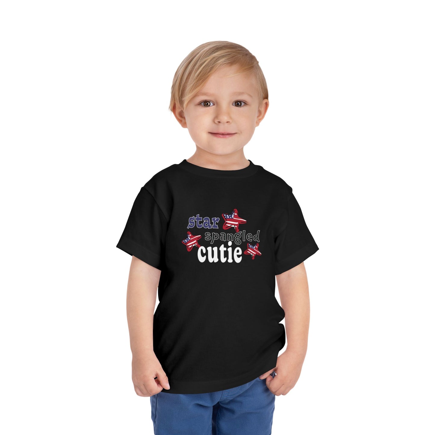 Black toddler t-shrit on a model with typography and patriotic stars, t-shirt says "star spangled cutie"