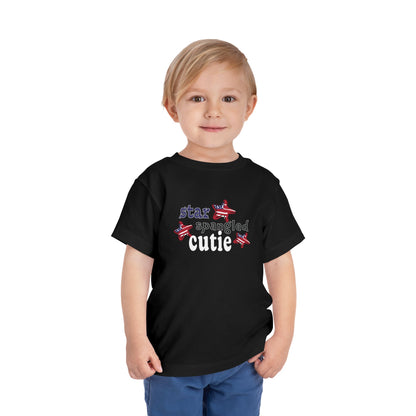 Black toddler t-shrit on a model with typography and patriotic stars, t-shirt says "star spangled cutie"