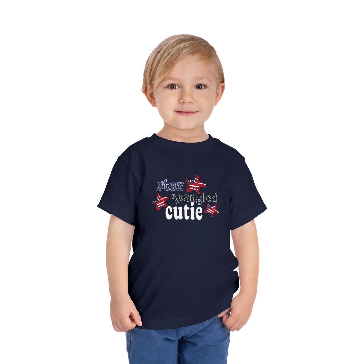 Navy toddler t-shrit on a model with typography and patriotic stars, t-shirt says "star spangled cutie"