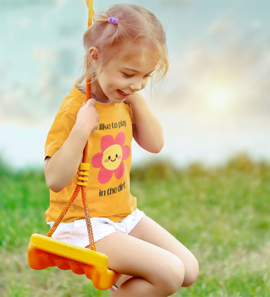 Toddler wearing “I Like to Play in the Dirt” shirt in a swing